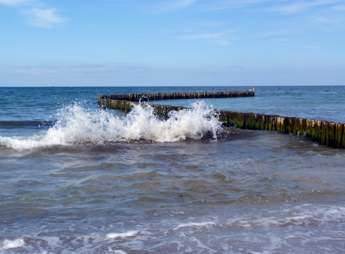 brechende Welle an Buhnenreihe